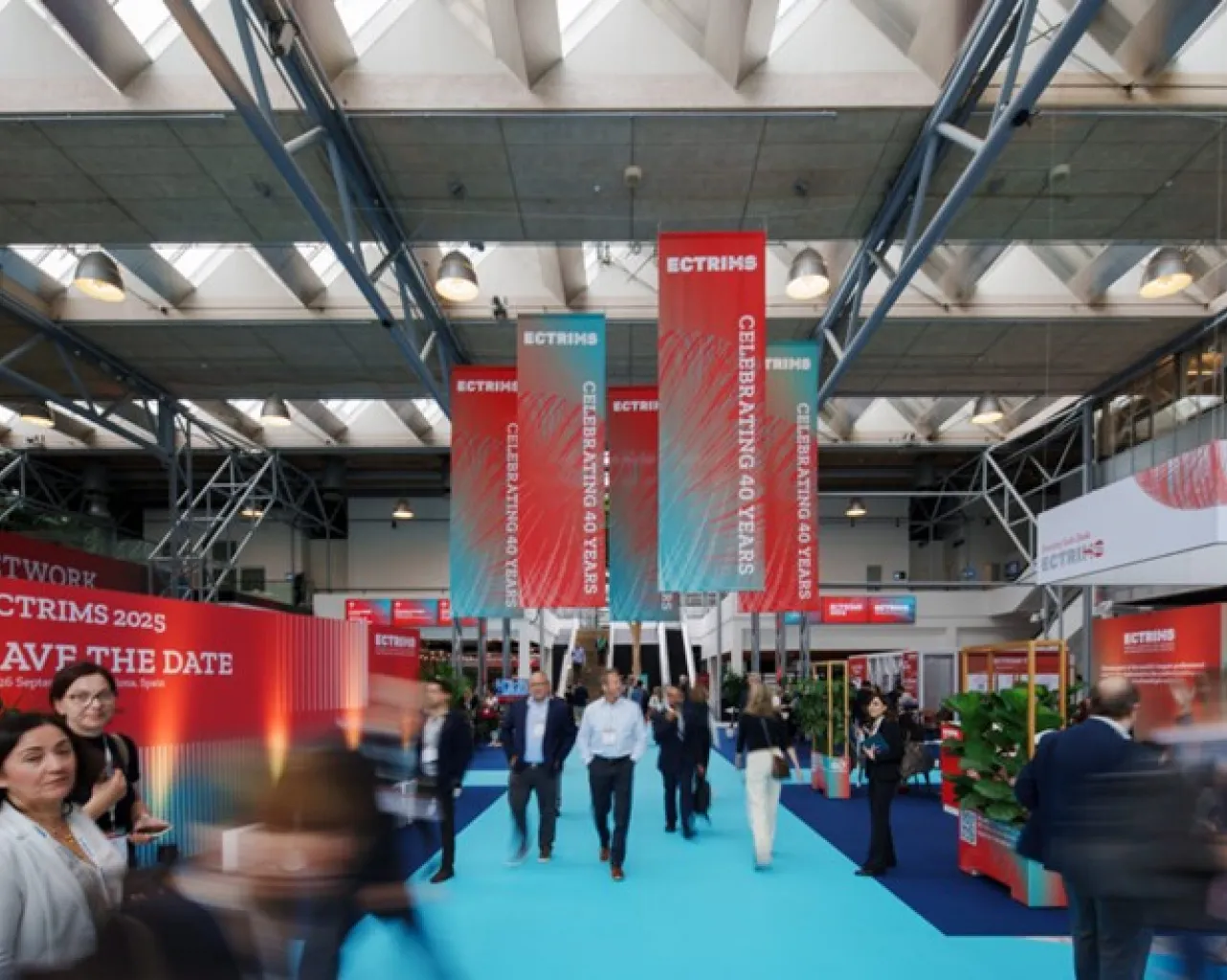 [Site du congrès de l’ECTRIMS où l’on peut voir des banderoles de bienvenue, des kiosques d’entreprise et des personnes participant à l’événement.]