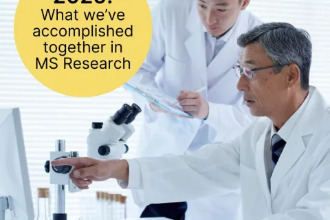Two researchers in white lab coats. One pointing to a computer screen and one holding a clip board.