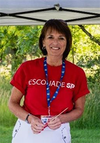 [Jocelyne Arcand, a short haired brunette wearing a red shirt outside]