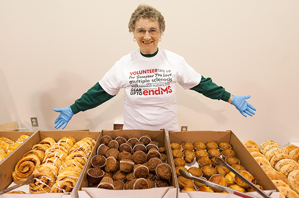 A volunteer proudly showing off a variety of baked goods.
