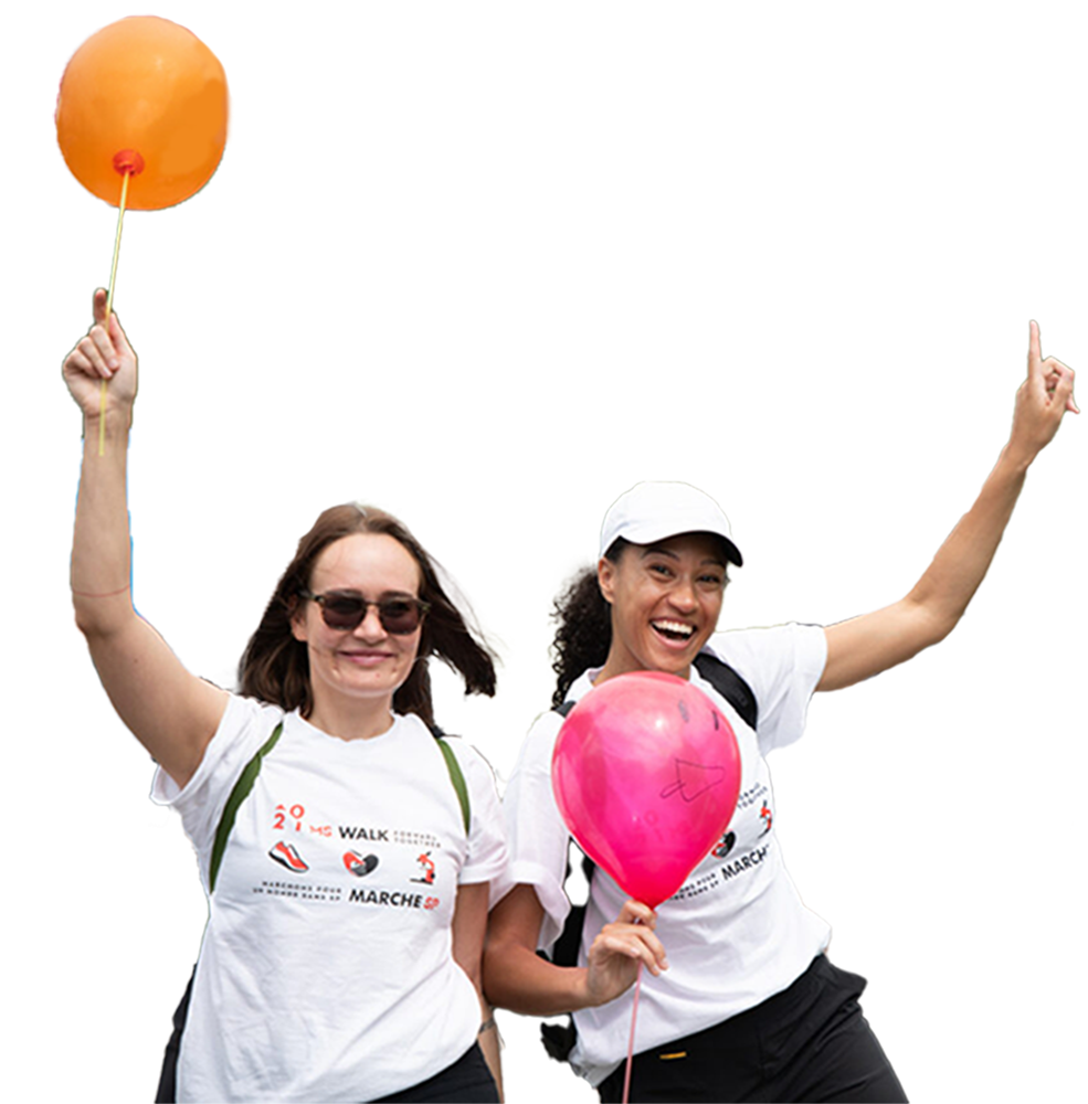 Two volunteers holding balloons and smiling.