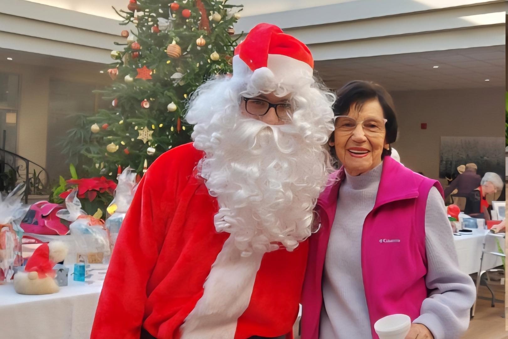 Le père noël, une femme et le sapin de noël