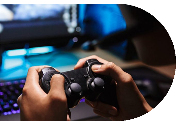 hands holidng a gaming controller in front of a PC