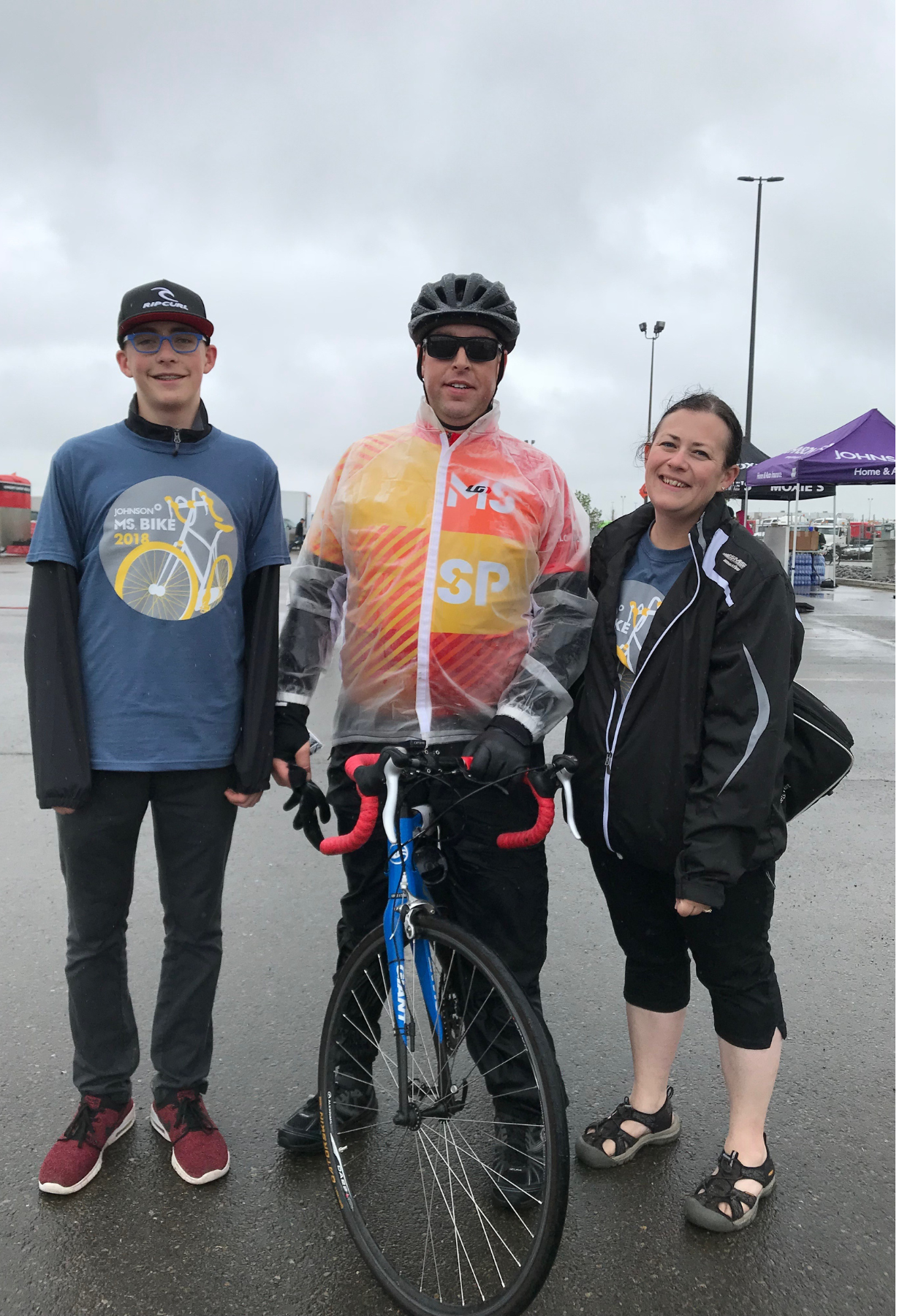 Erik and his mother and father posing with a bicycle outdoors at MS Bike.