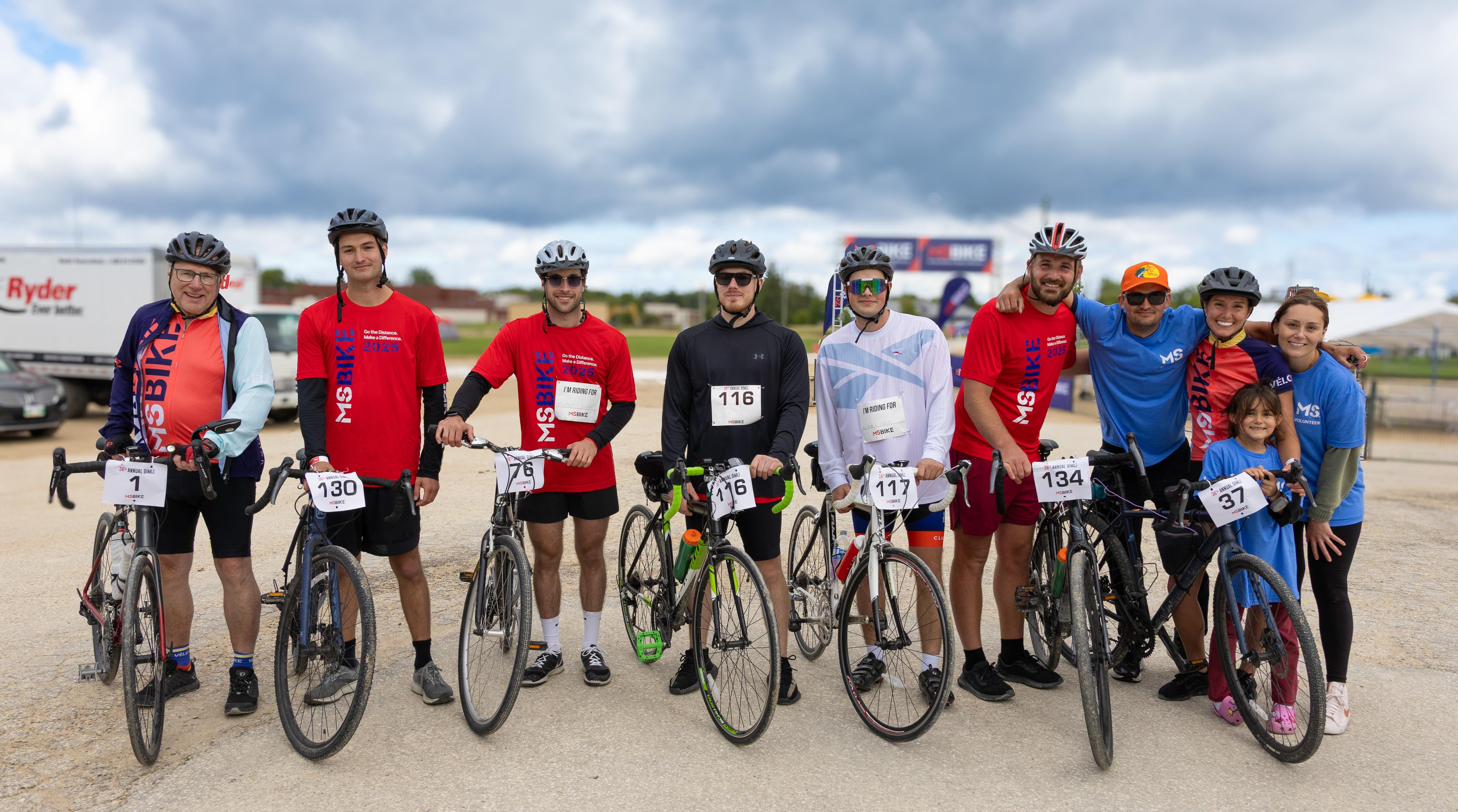 Mika and other MS Bike cyclists and volunteers posing together with their bikes.