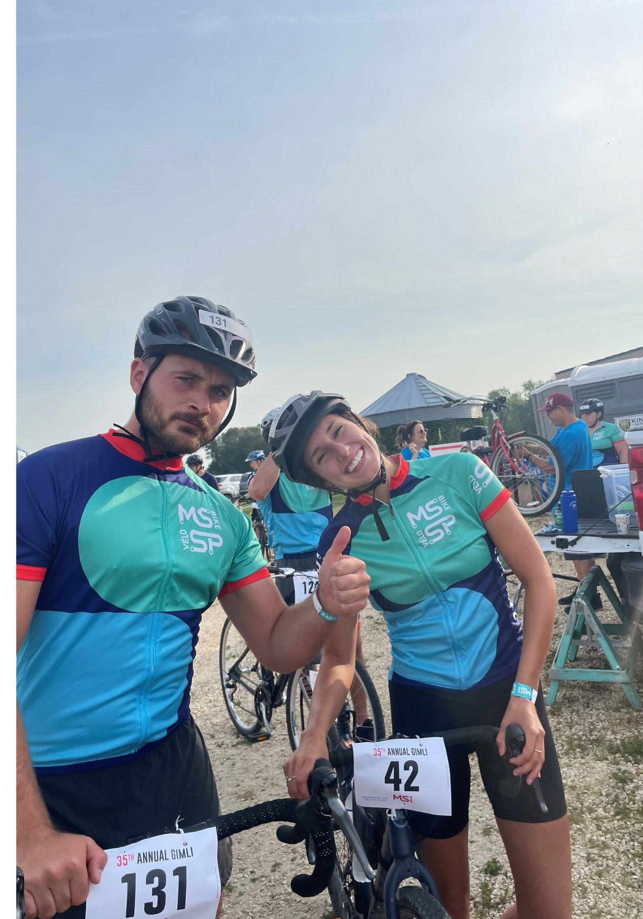 Mika and her husband smiling with their bikes, wearing helmets and their MS Bike gear.