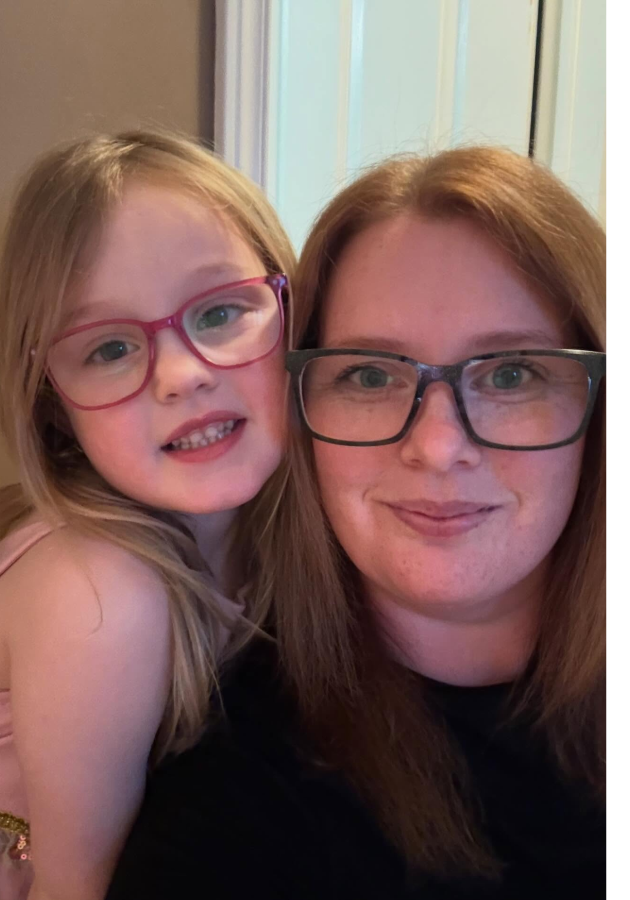 Janice and her daughter with glasses smiling together in a close selfie.