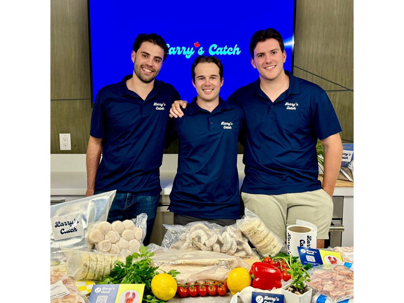 Larry's Catch team in matching navy polos standing behind a food display table.