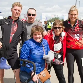 Alli and her family posing outdoors at MS Bike wearing MS Bike jerseys.
